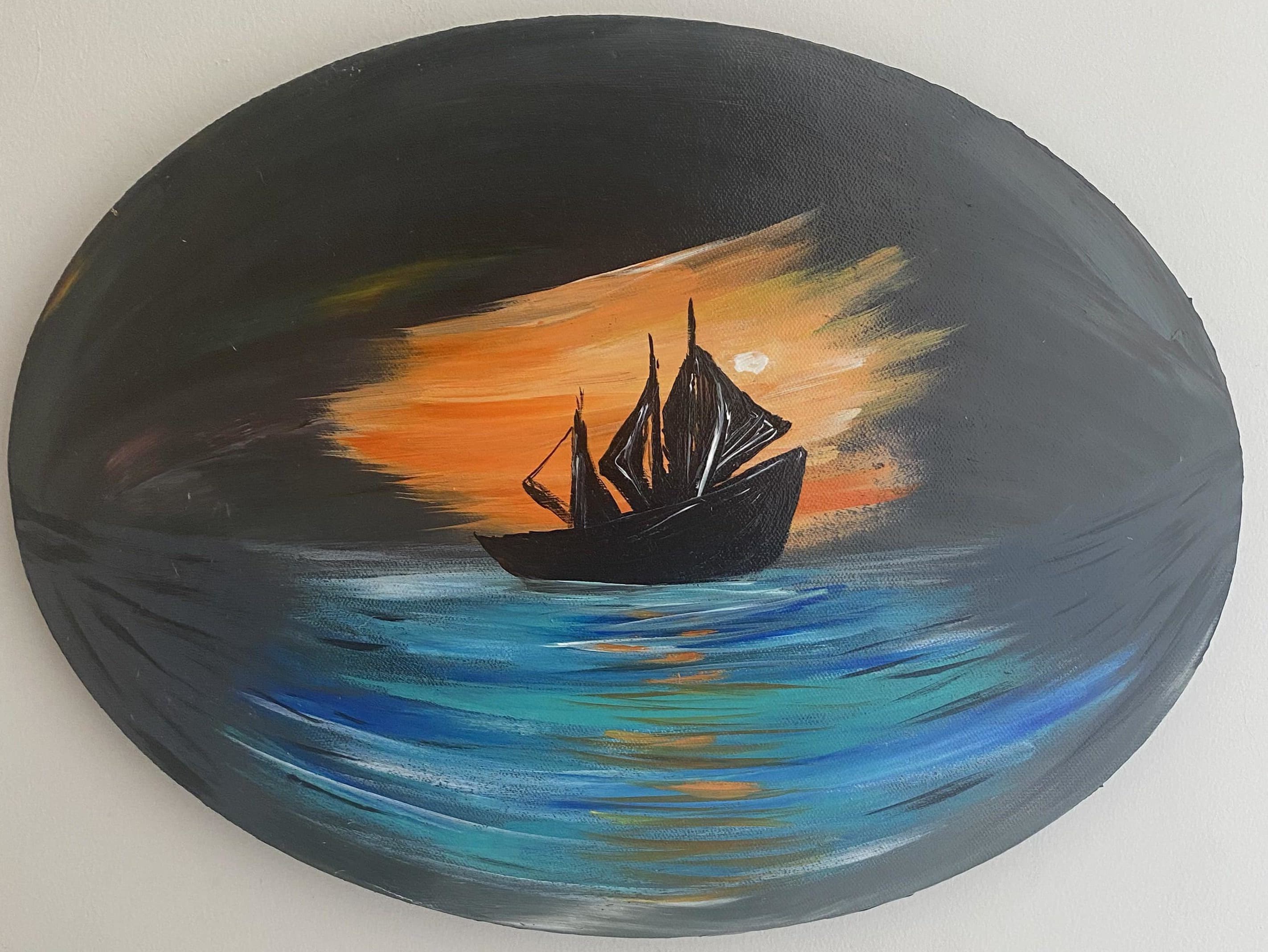 Round painting of a sailboat at sunset